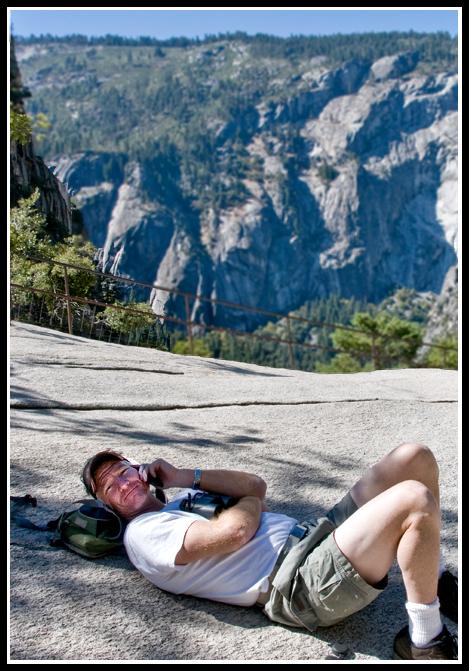 John reclines at his ease and phones home from the broad summit at Vernal Fall.