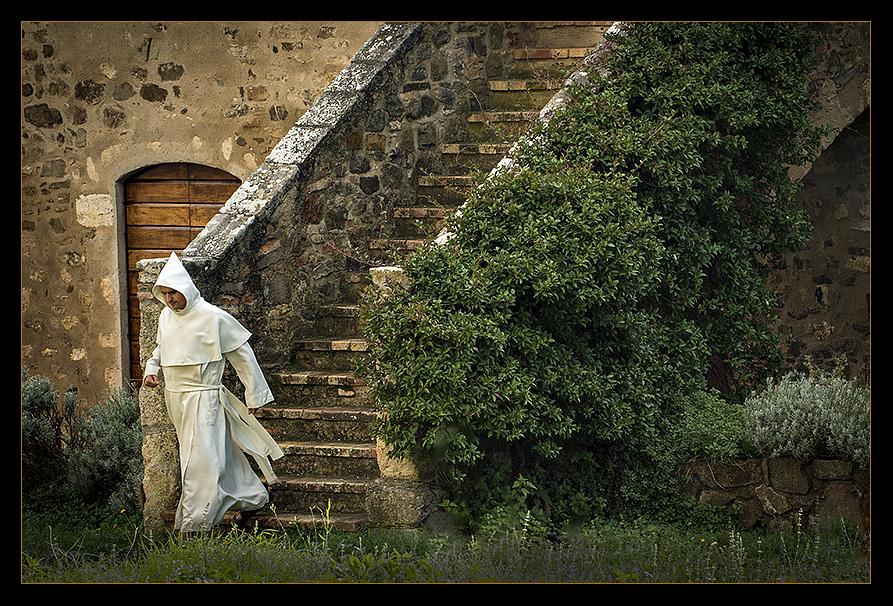 Rushing to one of the seven daily prayers, this monk from the 'Canons Regular' (priests living in community under the Rule of St. Augustine and sharing their property in common) prepares to enter the Abbey of Sant'Antimo and join his brothers in hauntingly beautiful Gregorian Chant.